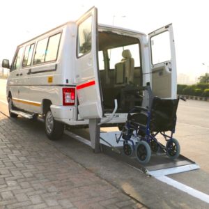 Image shows a wheelchair accessible van fitted with a hydraulic lift. The hydraulic lift has been opened and lowered so a wheelchair can get in it's platform. Vehicle can be used as a wheelchair patient ambulance, or a wheelchair taxi